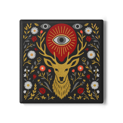 Square ceramic coaster, 4x4 inches, with cork backing. Charcoal tile showcases a golden stag head with antlers, surrounded by florals and an all-seeing eye in red and gold. Smooth printed surface; bold folk-art style. Witchy occult deer coaster for dark academia décor, bar cart, or living room. Square ceramic drink coaster with cork base, stag and eye design.